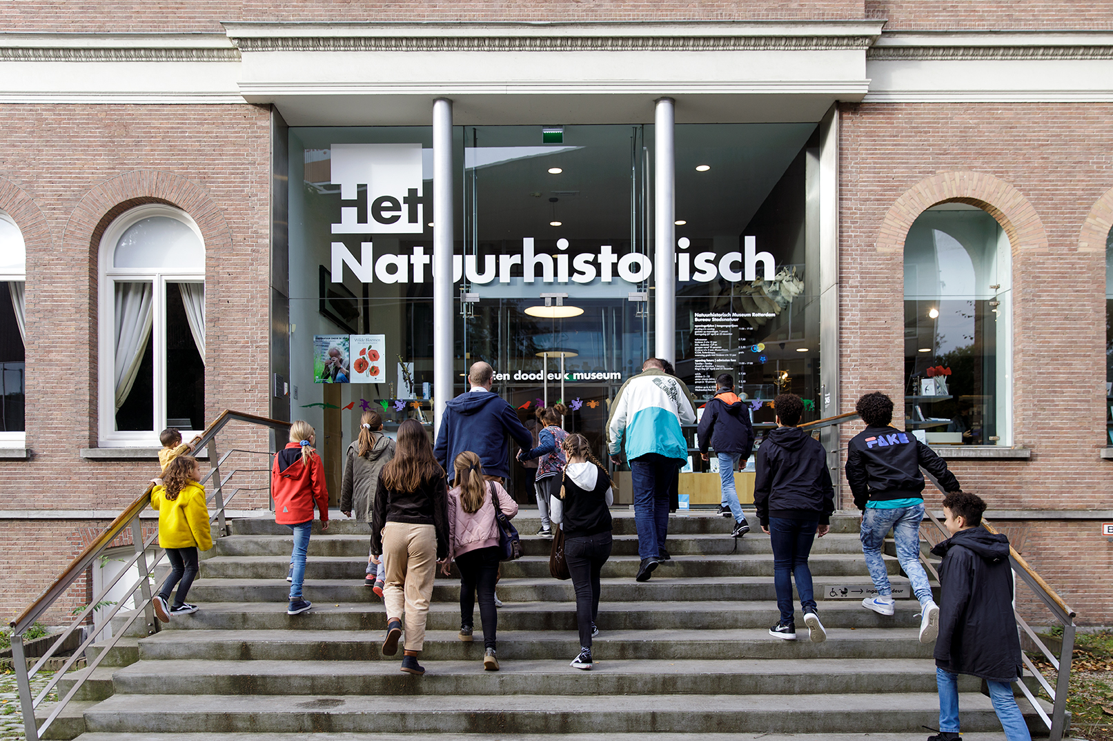 Bezoekers beklimmen de trap voor de ingang van het museum